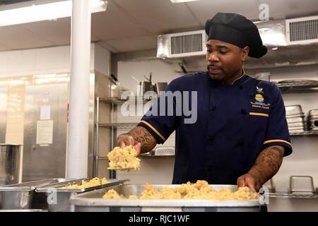 JACKSONVILLE, Fla. (Nov. 2, 2016) Petty Officer 2nd class Jarel Thomas von Naval Station Mayport's Oasis Kombüse bereitet Schweinefleisch gebratener Reis vor dem Mittagessen. Stockfoto