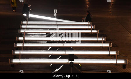 Ein paar beim Reiten auf der beleuchteten und musikalische Wippen der Kunst Installation mit dem Titel Wave-Field, Variation F, die in die Kohle tropfen Yards hinter Kings Cross Bahnhof in London installiert wurde. Stockfoto