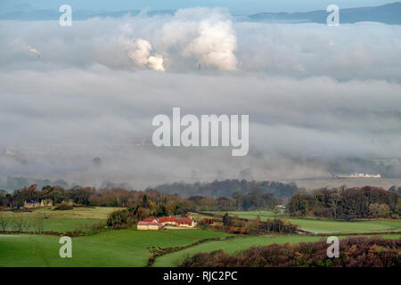 Anzeigen eines Bauernhauses in der Forth Valley und Emissionen aus der Raffinerie Grangemouth im Abstand angezeigt durch den Morgennebel. Stockfoto