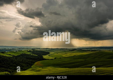 Luftaufnahme auf typische hügelige toskanische Landschaft mit Feldern und Bäumen, dunkle Gewitterwolken anfahren Stockfoto