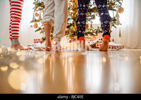 In der Nähe von drei Kindern Beine beim Dekorieren ein Weihnachtsbaum Stockfoto