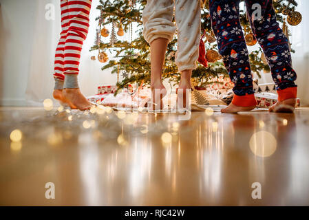 In der Nähe von drei Kindern Beine beim Dekorieren ein Weihnachtsbaum Stockfoto