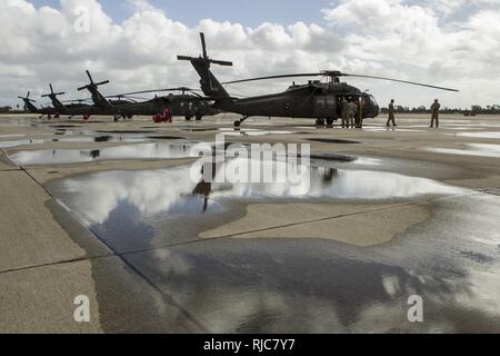 Ein Kalifornien Army National Guard UH-60 Black Hawk aircrew vom Los Alamitos Army Airfield Flugbetrieb, Los Alamitos, Kalifornien, bereitet zu starten, Jan. 9, 2018. Zwei Hubschrauber mit rescue Ausrüstung wurden von der zivilen Behörden mit Antwort zur Sturm-driven Schlammlawinen in Bereichen, die durch die jüngsten Waldbrände in Südkalifornien verbrannt zu unterstützen aktiviert. Acht Kalifornien Nationalgarde Hubschrauber wurden während des Zustandes aktiviert. Stockfoto