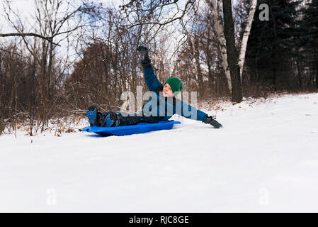 Junge auf einem Schlitten lachen, Wisconsin, United States Stockfoto