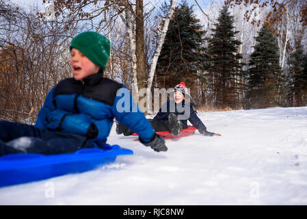 Zwei Jungen auf einem Schlitten lachen, Wisconsin, United States Stockfoto
