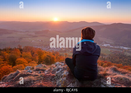 Junge Frau genießt die Aussicht vom hohen Aussichtspunkt der Bruchhauser Steine (Feldstein), Bruchhausen, in das schöne Sauerland im Herbst, Deutschland, Stockfoto