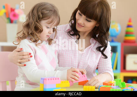 Portrait von Curly kleines Mädchen mit Mutter spielt Stockfoto