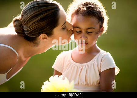 Junges Mädchen und ihre Mutter Tütü tragen in einem Park. Stockfoto