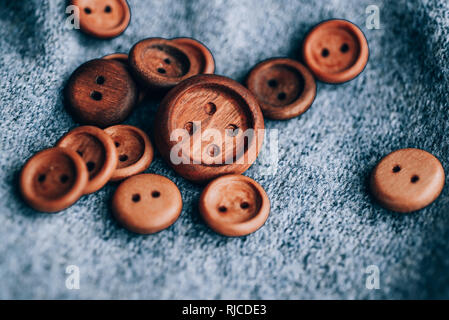 Holz- Schaltflächen, die zufällig auf einem grauen Hintergrund platziert werden Stockfoto