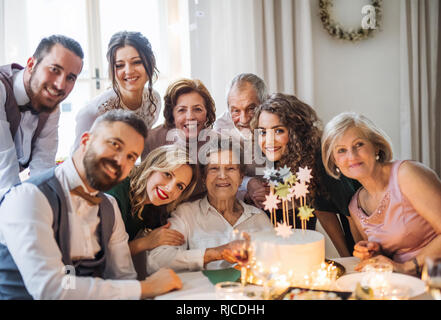 Eine ältere Frau mit multigeneration Familie feiert Geburtstag auf Indoor Party. Stockfoto