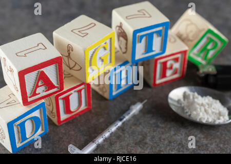 Wort "Tochterrichtlinien" in Blöcken mit Spritze geschrieben, Löffel mit Medikamenten (Mehl als eine Replik), und leichter. Suggestiv in der Familie gegen einen addicti Stockfoto