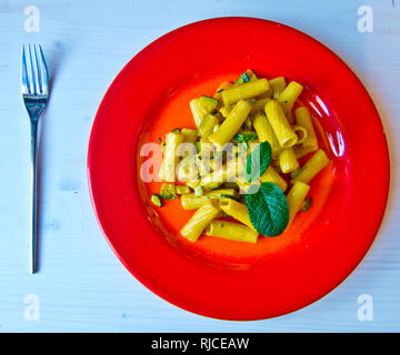 Nudelgericht gekrönt mit einer hellen gelben Sauce mit Gemüse, Safran und schmackhafte Kräuter Stockfoto