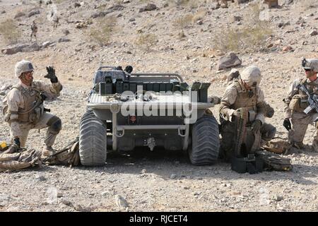 Marinesoldaten und Matrosen zu Kilo Unternehmen zugewiesen sind, 3.BATAILLON, 5. Marine Regiment vorbereiten Munition durchgeführt von einem Logistikunternehmen Multipurpose Unbemannte taktischen Transport (Log-MUTT), während in der integrierten Ausbildung Übung in der Marine Corps Air-Ground Combat Center, Twentynine Palms, Kalifornien teilnehmen. Dies ist eine Schulungsveranstaltung innerhalb Ihrer predeployment Schulungsplan. Das Marine Corps Warfighting Laboratory einige verschiedene Unmanned Aircraft Systems (UAS) und unbemannte Systeme (UGS) für die Marines während ihrer Ausbildung Zyklus zu beschäftigen. Stockfoto