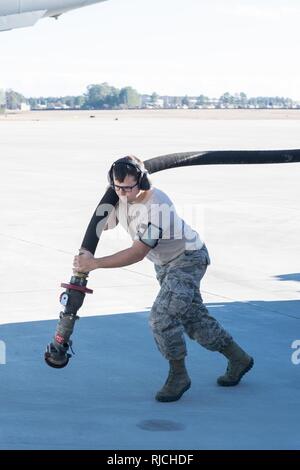 Papst Army Airfield, N.C. - Senior Airman Kyle König, ein Brennstoffe Techniker in der 43d Air Base Squadron, trägt ein Schlauch von einer Betankung Stapler nach einem 437Th Airlift Wing C-17 Globemaster III, während bei der Unterstützung der gemeinsamen airdrop Ausbildung auf Grün Rampe hier Jan. 10, 2018. Die 43 d-Air Mobility Operations, die Teil des Air Mobility Command, unterstützt die Luftbrücke Schulung und reale Vorgänge für Armee und Luftwaffe konventionelle und Special Operations Units in Fort Bragg, bewegen Millionen von Pfund an Fracht und Tausende von Passagieren pro Jahr. Stockfoto