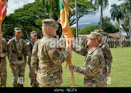 Oberst Shannon-Mikel Lucas übergibt der 8 Military Police Brigade, um Farben auf die eingehenden Brigade Senior Berater angeworben, Command Sgt. Maj. William Mayfield, während ein Wechsel der Verantwortung Zeremonie am 9. Januar auf Schofield Barracks" Hamilton Feld. Stockfoto