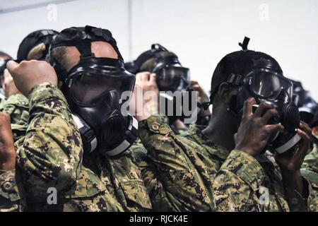 GREAT LAKES, Illinois (Jan. 10, 2018) Praxis Rekruten entfernen M-50 Gasmasken bei der grundlegenden chemischen, biologischen und radiologischen Verteidigung (CBR-D) Ausbildung an der USS Chief Training Service am Training Befehl Rekrutieren (RTC). Rekruten Praxis CBR-D durch das praktische Lernen, was bedeutet, dass Rekruten "Zug wie wir kämpfen". USS Chief's Personal von Fachexperten verbringen mehrere Tage Training Rekruten, die Themen reichen von grundlegenden damage control equipment bis zu fortgeschrittenen Techniken der Brandbekämpfung an Bord. Über 30.000 bis 40.000 Rekruten Absolvent jährlich nur von Boot Camp der Marine. Stockfoto