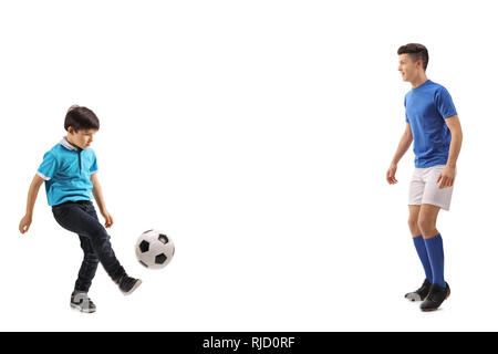 Volle Länge Schuß eines kleinen Jungen Fußball spielen mit einem älteren Jungen auf weißem Hintergrund Stockfoto