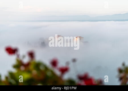 Chiusi Scalo Nebel Nebel Sonnenaufgang auf dem Dach Häuser Gebäude in Umbrien, Italien in der Nähe der Toskana mit Wolken bedeckt, Stadt Stadtbild und Blumen in Stockfoto