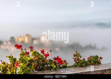 Chiusi Scalo Nebel Nebel Sonnenaufgang der Häuser Gebäude in Umbrien, Italien in der Nähe der Toskana mit Wolken bedeckt, Stadt Stadtbild und auf Blumen Fokus ga Stockfoto