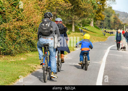 SWANSEA, WALES - Oktober 2018: Familie, Radfahren entlang der Küste von Mumbles nach Swansea. Stockfoto