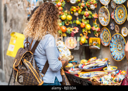 Orvieto, Italien - 3. September 2018: Eine Frau Einkaufsmöglichkeiten für Souvenirs in der kleinen italienischen Stadt Stadt von Street Hersteller, mit denen die Platte am Einzelhandel Stockfoto