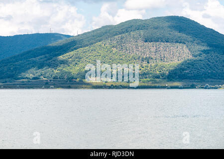 Grün Sommer Park in Punta del Lago mit Vico See Terni Provinz niemand Landschaft Tag Blick auf blauem Wasser und Berg friedliche Stockfoto