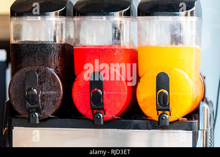 Drei Maschinen closeup von Slush slushie kalte Getränke mit Matschigen Eis und bunten Farben für erfrischende Sommer mit Schwarz, Rot und Gelb Stockfoto