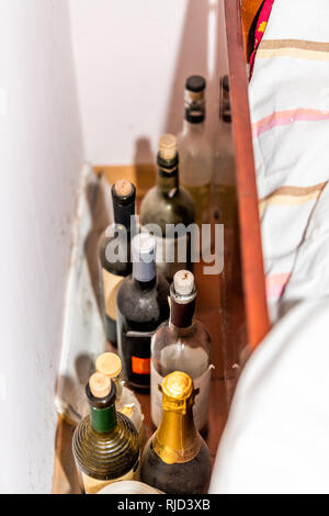 Vielen staubigen alten Wein und Sekt Flaschen mit Naturkorken durch Bed in alkoholischen Home Haus im rustikalen Cottage Farm House home Kabine Datscha closeup Stockfoto