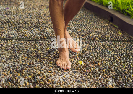 Menschen gehen auf eine strukturierte, mit Kopfstein Pflaster, Reflexzonenmassage. Pebble Stones auf dem Bürgersteig für Fußreflexzonenmassage. Stockfoto