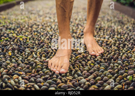 Menschen gehen auf eine strukturierte, mit Kopfstein Pflaster, Reflexzonenmassage. Pebble Stones auf dem Bürgersteig für Fußreflexzonenmassage. Stockfoto