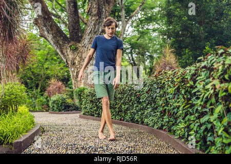 Menschen gehen auf eine strukturierte, mit Kopfstein Pflaster, Reflexzonenmassage. Pebble Stones auf dem Bürgersteig für Fußreflexzonenmassage. Stockfoto