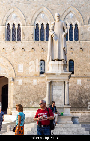 Siena, Italien - 27. August 2018: historischen, mittelalterlichen Altstadt Dorf in der Toskana mit Statue im Palazzo Salimbeni Bandini und Menschen Stockfoto