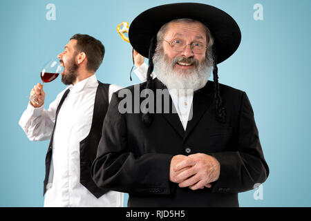 Portrait von alten Senior orthodoxen Hasdim jüdischen Mann mit koscherer Wein bei jüdischen Fest Purim im Studio. Die purim, jüdische, Festival, Urlaub, Feier, Judentum, Gebäck, Tradition, Cookie, Religion Konzept. Stockfoto