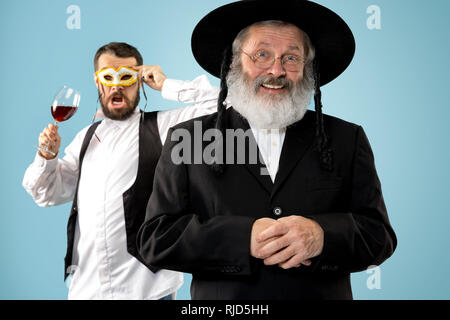 Portrait von alten Senior orthodoxen Hasdim jüdischen Mann mit koscherer Wein bei jüdischen Fest Purim im Studio. Die purim, jüdische, Festival, Urlaub, Feier, Judentum, Gebäck, Tradition, Cookie, Religion Konzept. Stockfoto