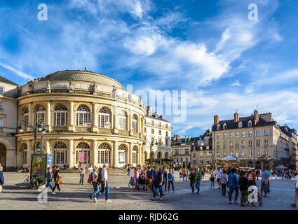 Menschen flanieren in der Fußgängerzone Rathausplatz vor der gerundeten Fassade der Oper durch einen sonnigen Samstag Nachmittag unter einem blauen Himmel. Stockfoto