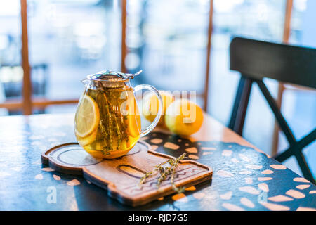 Tasse Kräutertee mit Thymian und Zitrone serviert mit Board auf dem Tisch. Stockfoto