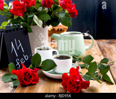 Postkarte für Valentinstag und rote Rosen. Kaffee und Blumen für eine Romanze Frühstück. Holz- Hintergrund und Wasserkocher. Platz kopieren Stockfoto