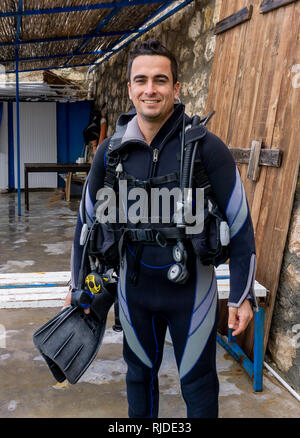 Portrait einer jungen gutaussehenden Mann diver bereit, Tauchen mit kaltem Wasser Neoprenanzug, Flossen, Auftrieb Kompensator, Regler, alternative Luftversorgung Stockfoto