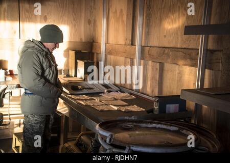 Senior Master Sgt. Tonya Camarata, die Sicherheit superintendant von der 179th Airlift Wing, schaut über Eingesackt live Runden in der Munition Storage Area hier Jan. 18, 2018. Camarata und ihr Team waren anwesend, die Übertragung von Munition hier der 200 RED HORSE Geschwader zu übersehen. Camp Perry, Ohio. Stockfoto