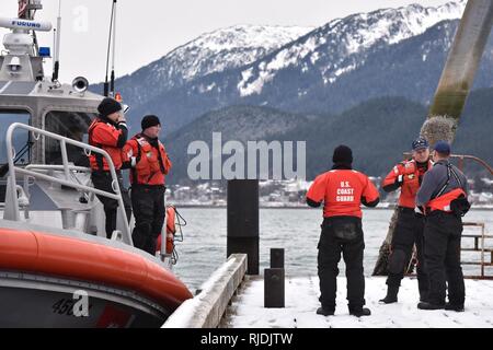 Mitglieder der Coast Guard Station Juneau haben eine Diskussion vor Beginn der Mann über Bord Ausbildung in Juneau, Alaska, Jan. 24, 2018. Station Juneau durchgeführt, um die Mann-über-Bord-Position Bohrer bei Frost zu erhalten neue Mitglieder boatcrew qualifiziert. Stockfoto