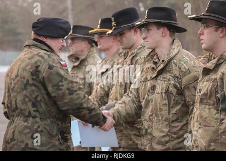 Oberst Diplomat Dariusz Parylak, Commander, 10 gepanzerte Kavallerie Brigade schüttelt Hände mit US-Soldaten der 5. Staffel, 4. Regiment, 2. gepanzerte Brigade Combat Team, 1.Infanterie Division, während einer abschiedszeremonie von 10. ACB in Swietoszow, Polen, 31.01.22, gehalten Abschied von der Squadron zu bieten, da sie ihre Operationen Übergang zu Grafenwöhr, Deutschland für geplante Ausbildung. (Polnisches Land Kräfte Stockfoto