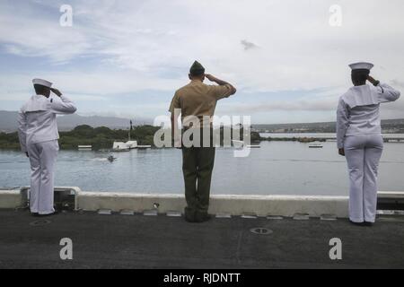 PEARL HARBOR NAVAL BASE, HI-Marinesoldaten und Matrosen mit dem 15 Marine Expeditionary Unit und Amerika amphibischen Bereit Gruppen an Bord amphibisches Schiff USS America (LHA 6) Salute, wie sie das USS Arizona Memorial verlassen, Jan. 25, 2018. Manning der Schienen ist ein Naval Tradition jede Bereitstellung von Schiff führt und ist eine Methode der ehrenkompanie oder Rendering Ehren durch Marineschiffe verwendet. Die 15. MEU und Amerika ARG sind derzeit auf eine Routine für sieben Monate, um die Bereitstellung zu den USA 3., 5. und 7 Flotte Bereiche des Betriebes als Reaktion auf Krisen und Kontingenz Kraft eingesetzt. Stockfoto