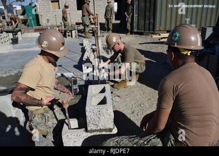 PORT HUENEME, Calif (Jan. 24,2018) Seabees, zugeordnet zu den Naval Mobile Konstruktion Bataillon Fünf (NMCB 5), zur Festlegung der Zement- und Bausteine der Grundstein für ein neues Gebäude in einem Baustein zur Ausbildung zu schaffen. NMCB 5 ist die Durchführung von Schulungen zu helfen, die Sicherheit, die richtige Technik Verwendung, gewährleisten und neue Seabees mit der Ausrüstung vertraut machen in der Vorbereitung für eine bevorstehende Bereitstellung. Stockfoto