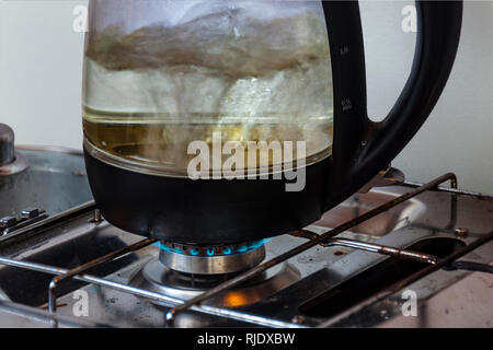 Schnelle kochen. Moderne elektrische Wasserkocher kochen bei GAZ-Herd. Stockfoto