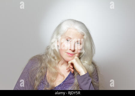 Porträt einer reifen Frau mit schönen Curly langes graues Haar vor weißem Hintergrund, kopieren. Stockfoto