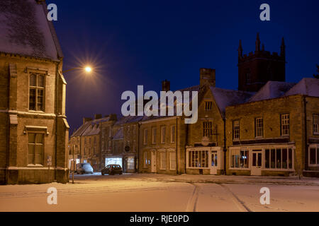 Marktplatz Geschäfte am frühen Morgen Schnee vor der Morgendämmerung. Verstauen auf der Wold, Cotswolds, Gloucestershire, England Stockfoto