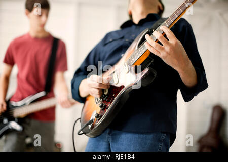 Mitte der erwachsene Mann eine E-Gitarre mit Begeisterung spielen. Stockfoto