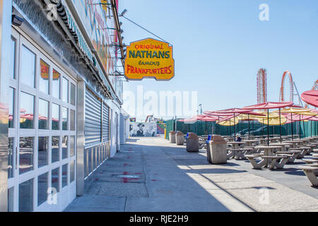 24. März 2018: Ikonischer Boardwalk mit Parachute Drop und Nathans Hot Dogs in Coney Island, Brooklyn Stockfoto