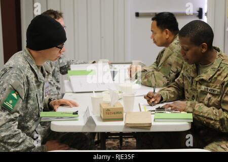 Sgt. 1. Klasse Larhonda Hankins, eine Armee der Spezialist für 6 Bataillon, 1. Sicherheit Kraft Unterstützung Brigade, geht über Berichte mit einer Rolle als Mitglied der afghanischen nationalen Armee während der Logistik übung, die Teil des gemeinsamen Joint Readiness Training Center Rotation, in Fort Polk, Louisiana, Jan. 19, 2018. Die Logistik hat die 1 SFAB LATs neben der ANA zu trainieren, beraten, unterstützen, begleiten und Ihnen ermöglichen, logistisch eine Mission, die von der ANA Corps übergeben wird gearbeitet. Stockfoto