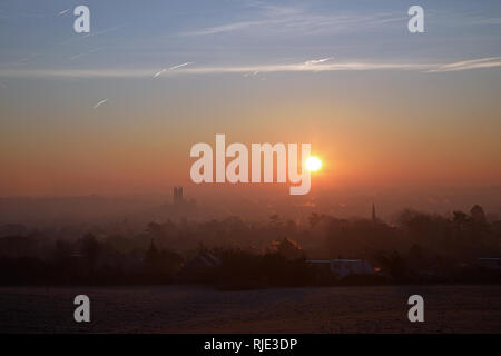 Sonnenaufgang über Canterbury an einem kalten, klaren Januar Vormittag mit Flugzeug Kondensstreifen am Himmel. Stockfoto